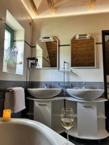 LožišćeVilla Monica的浴室设有两个水槽和一杯葡萄酒