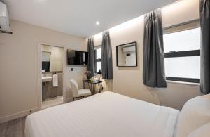 伦敦Kings Cross Express Hotel的一间带白色床的卧室和一间浴室