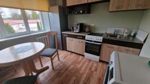 奥格雷Apartamenti dzīvoklis Ogre.的小厨房配有桌子和桌椅