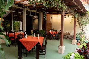 危地马拉Hostal Donde Regina的庭院里的餐厅,配有红色的桌椅
