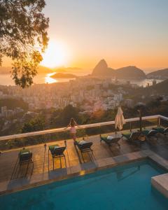 里约热内卢Vila Santa Teresa的站在游泳池旁的女人,欣赏日落