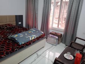 勒克瑙Ishita villa的一间卧室配有一张床、一张桌子和一个窗户。