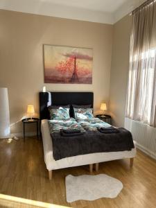 松兹瓦尔Rentalux Apartments at Nytorget的一间卧室配有一张床、两张桌子和两盏灯。