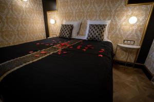 索恩河畔自由城Appartement d'exception avec Jacuzzi的一间卧室,床上有红色玫瑰