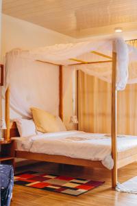 莫罗戈罗Edelwyss-Inn的一间卧室配有一张天蓬床和地毯。