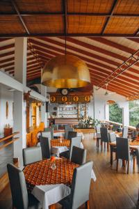 莫罗戈罗Edelwyss-Inn的一间带桌椅和大型天花板的餐厅
