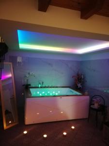 特雷卡斯塔尼A Trecastagni - Etna Home的紫色照明的客房内的大浴缸