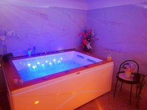特雷卡斯塔尼A Trecastagni - Etna Home的紫色照明的客房内的大浴缸