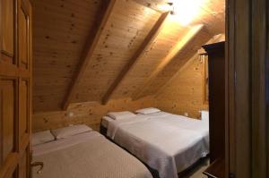 科拉欣Brvnara Bjelasica的木制阁楼上的卧室配有两张床