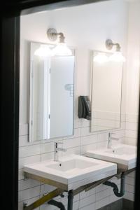 渥太华Saintlo Ottawa Jail Hostel的浴室设有2个水槽和2个镜子
