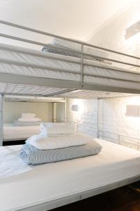 渥太华Saintlo Ottawa Jail Hostel的卧室设有两张双层床,拥有白色的墙壁