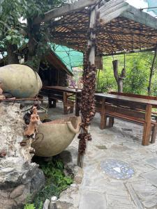 TekherParsamyan's Art and Craft house的野餐区,有长凳和一束蜜蜂