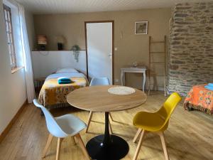 Conques-en-RouergueLA CONQUISE的配有桌椅和床的房间