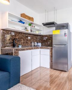 托尔图格罗BUDDA HOME的厨房配有冰箱和蓝色沙发。