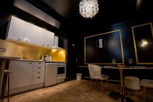 索恩河畔自由城Appartement d'exception avec Jacuzzi的厨房配有白色橱柜、桌子和吊灯。