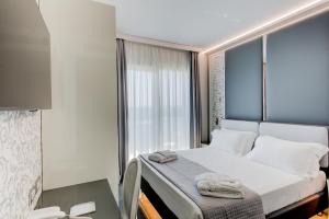 里米尼Hotel Due Mari & SPA的一间卧室配有床,窗户配有毛巾