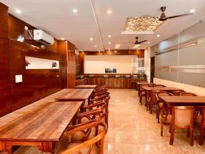 哈里瓦Hotel The Tirath View的用餐室配有木桌和椅子