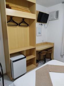 迪亚曼蒂纳Pousada do Garimpo的客房设有小书桌和小冰箱。