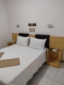 迪亚曼蒂纳Pousada do Garimpo的卧室配有一张白色的大床和一张桌子
