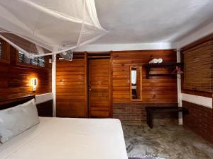 马祖特Casa Gaviota的一间卧室设有一张床和木墙