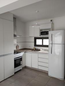 门多萨Mendoza Viejo Tonel的白色的厨房配有白色橱柜和冰箱。