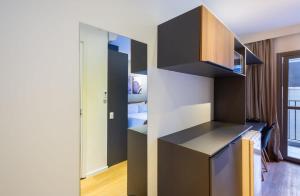 圣保罗BHomy Brooklin - 300m estacão da Brooklin BUR101的一间厨房,配有黑色橱柜和一张位于客房内的床