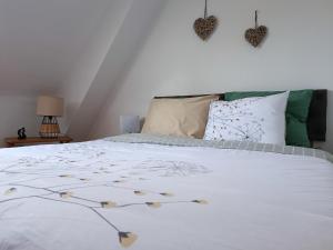 Huisnes-sur-MerVue unique sur le Mont St Michel的一间卧室配有带白色床单和枕头的床。