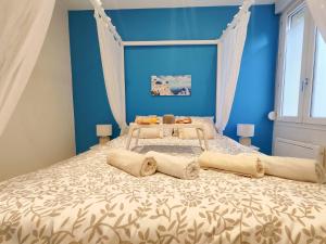 勒阿弗尔Évasion Santorin - Jacuzzi & Relax的蓝色卧室配有带窗帘的大床