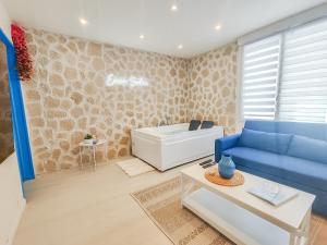 勒阿弗尔Évasion Santorin - Jacuzzi & Relax的客厅配有蓝色的沙发和浴缸