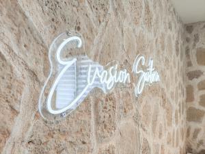 勒阿弗尔Évasion Santorin - Jacuzzi & Relax的石墙边的标志