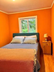奥索尔诺the house of flowers的一间卧室设有橙色的墙壁和一张带窗户的床