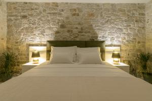 特罗吉尔Sobe Bartul Trogir的一间卧室配有一张大床和两盏灯