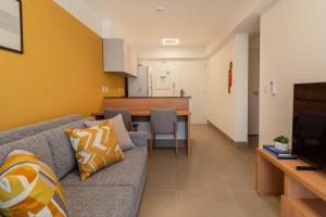 圣保罗BHomy Perdizes Novo e perfeito para 4 DH302的带沙发的客厅和用餐室