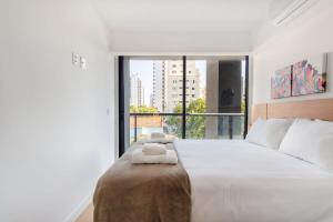 圣保罗BHomy Perdizes Novo e perfeito para 4 DH302的一间卧室配有一张大床和两条毛巾