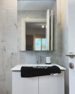 阿特米达Liakada Guest House的浴室水槽和柜台上的黑色毛巾