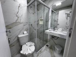 坎波斯杜若尔当Pousada Kaliman Luxo的带淋浴、卫生间和盥洗盆的浴室