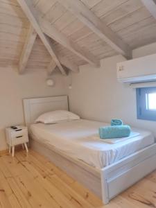 艾拉方索斯Maria’s family house’s的铺有木地板的客房内的一张白色床