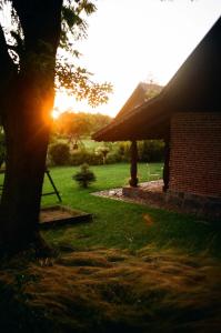 吉日茨科Poganty - Mały Domek的树后有太阳的房子