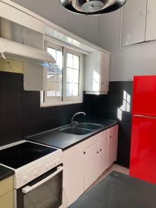 AndravídaJIM的厨房配有水槽和红色冰箱