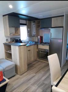 滨海皮里亚克Mobil home的厨房配有木制橱柜和不锈钢用具