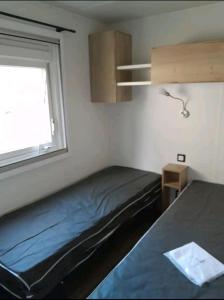 滨海皮里亚克Mobil home的一间小卧室,配有床和窗户