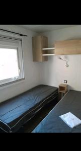 滨海皮里亚克Mobil home的一间小卧室,配有床和窗户