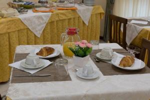 伊索拉迪卡波里祖托Albergo Bed and breakfast FLORIDA的一张桌子,上面放着羊角面包和鲜花