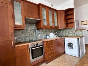 波兹南Kozia 24/25的厨房配有木制橱柜、洗衣机和烘干机
