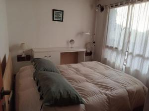 玛德琳港Para Toda la Familia的一间卧室配有一张带绿色枕头的床。