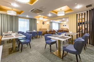 阿斯塔纳阿斯塔纳贝斯特韦斯特酒店的一间配备有桌子和蓝色椅子的用餐室