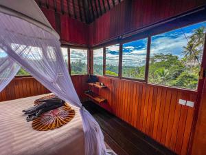 乌布Made Punias Jungle Paradise的一间卧室配有一张带天蓬和窗户的床