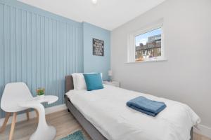 伦敦Waterside 4 Bed Apartment的卧室配有白色的床和白色椅子