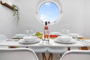 伦敦Waterside 4 Bed Apartment的一间白色的用餐室,配有一张桌子和一瓶葡萄酒