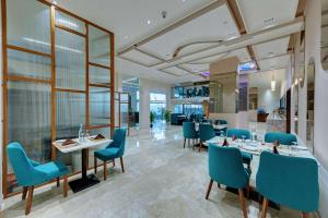 AdalajComfort Inn Sapphire, Chandkheda的一间配备有蓝色椅子和桌子的用餐室
